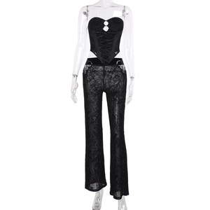 Détail d'un haut bustier en dentelle noire et d'un pantalon évasé aux motifs floraux ajourés