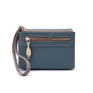 Detail of teal pebbled leather wallet with multi-layer zippers and gold leaf pendant