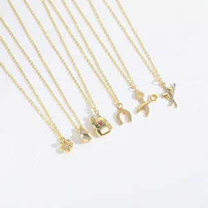 Selection of retro gold pendants including victory sign, horseshoe, and gemstone designs