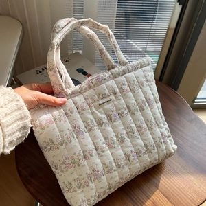 Close-up of quilted cotton tote bag featuring floral patterns and rabbit illustrations