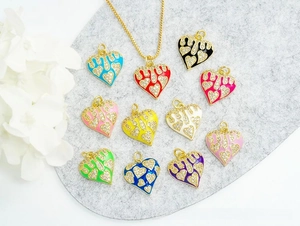 Detailed close-up of 18K gold plated heart charms with colorful enamel and pavé crystals