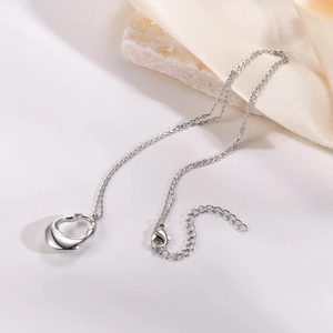 Macro detail of irregular hollow brass pendant necklace with a polished silver finish