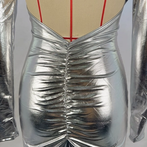 Détail de la robe moulante argentée avec dos froncé et manches longues élégantes