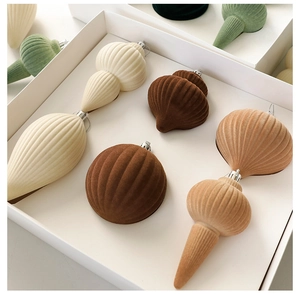 Macro detail of assorted flocking Christmas balls in earthy tones inside a premium gift box