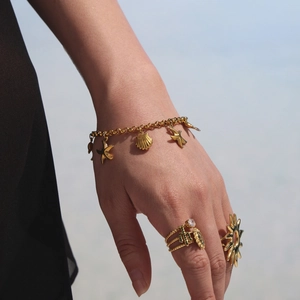 Parure de bijoux océan dorée avec bracelet coquillage et bagues soleil élégantes