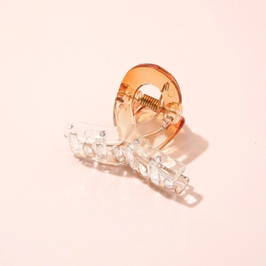 Close-up of translucent gradient amber acetate hair claw clip with golden metal spring