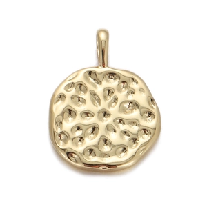 Detailed view of a gold round pendant with a hammered texture and hanging loop on white