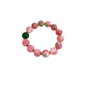 Elegant gold-plated ceramic beaded bracelet with pink floral patterns and green bead accents