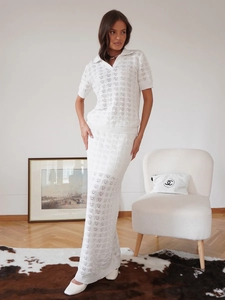 Detail of white knit two-piece set featuring geometric hollow-out crochet and polo collar
