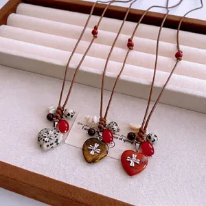 Collier bohème avec pendentifs en pierre en forme de cœur et ornements de croix en métal