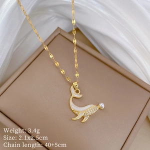 Macro detail of dolphin necklace with sparkling cubic zirconia and pearl on silk fabric