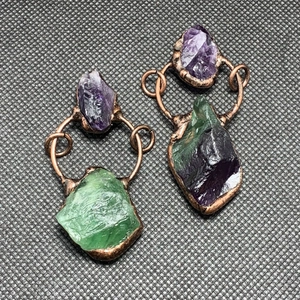 Detalle de pendientes de bronce hechos a mano con amatista bruta y fluorita verde natural