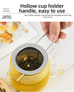 Close-up of 304 stainless steel tea infuser with dual long handles on a glass cup