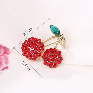Cute cherry brooch pin with red crystals and green gemstone leaf in gold finish