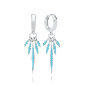 Vue macro de boucles d'oreilles argentées avec zircons turquoise sur fond blanc pur