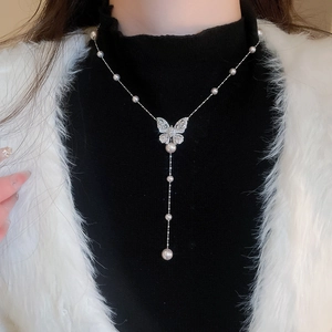 Dettaglio della collana con ciondolo a farfalla in zircone e perle su catena argento
