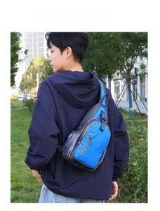 Waterproof blue nylon crossbody bag shown in outdoor setting with multiple zipper compartments