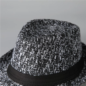 Close-up of black and white melange knit fabric texture and ribbon on the fedora hat