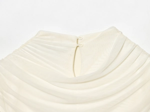 Detail of white mesh dress neckline with layered pleats and double button closure