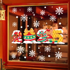 Close-up of festive 2025 reindeer and snowflake window stickers on red frame glass