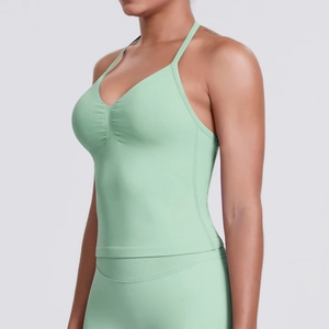 Detail of mint green sports bra featuring V-neckline and ruched chest fabric design
