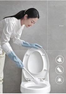 Close-up of long blue PVC cleaning gloves with floral sleeves in a bathroom setting