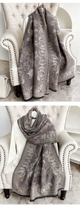 Close-up of deep brown paisley scarf with soft tassel edges on a vintage armchair