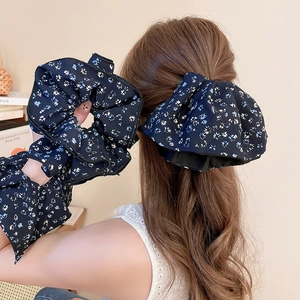 Floral chiffon scrunchie detail showing navy blue fabric texture and wrist styling