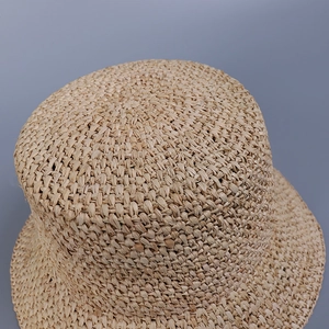 Macro detail of high-quality raffia straw hat showing precise cross-weave texture