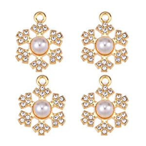 Detailed view of four golden snowflake pendants with central pearl and rhinestones