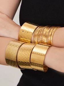 Vue détaillée de larges bracelets en acier plaqué or 18 carats aux motifs en relief variés