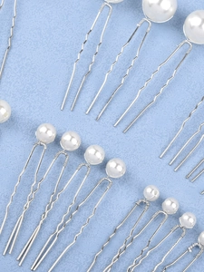 Detailed view of pearl U-shaped hairpins in various sizes for bridal wedding hairstyles