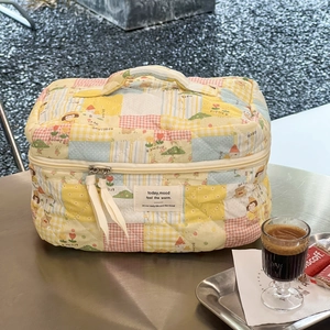 Nahaufnahme der gesteppten Kosmetiktasche auf Tisch mit Kaffee und Gebäck-Deko