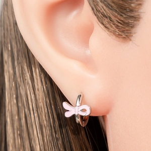 Pink bow-shaped metal hoop earrings shown on model for a sweet and stylish look