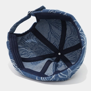 Macro view of blue denim Miki Hat interior with leaf pattern and metal buckle