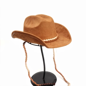Détail d'un chapeau de cowboy en daim marron avec perles blanches et mentonnière en bois