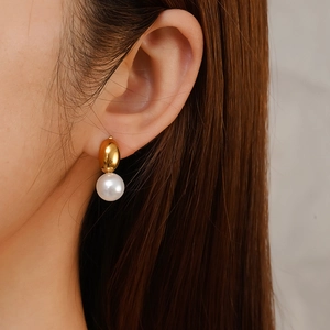 Elegant 18K gold plated oval stud earrings with white pearl inlay on model