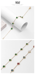 Detail of gold heart zircon bracelets with green, blue, pink and white stones