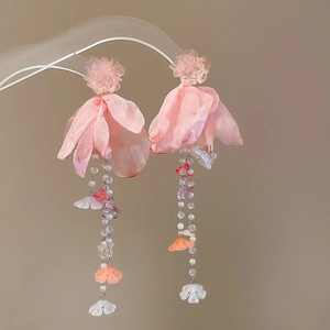 Detailed view of pink floral tassel earrings with pastel beads and fabric petals