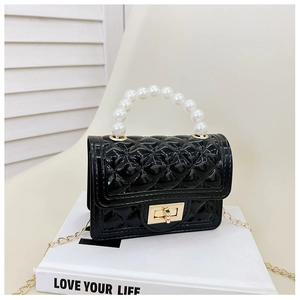 Macro detail of black quilted jelly bag with pearl handle and golden twist lock