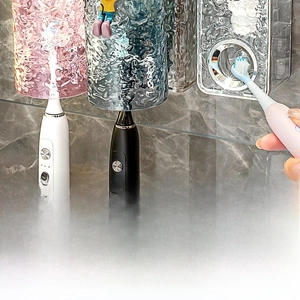 Detail view of wall-mounted toothbrush holders with ripple texture cups on marble wall