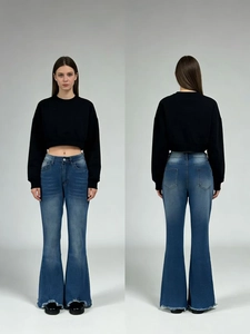 Detail of high-waist flared blue jeans with raw hem and distressed knee finish
