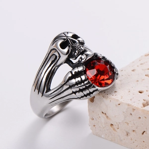 Detailed side view of punk skull ring in vintage silver with a red zircon center stone