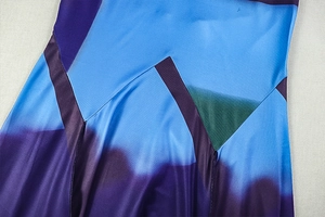 Détail du tissu à imprimé géométrique bleu et violet avec texture soyeuse et coutures