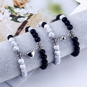 Detail of beaded couple bracelets with heart magnetic clasp on a soft grey velvet display