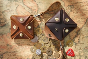 Macro shot of brown square leather coin purses with metal snap and retro map background