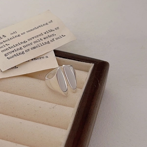 Close-up of a minimalist silver open ring with dual oval split design in a velvet box