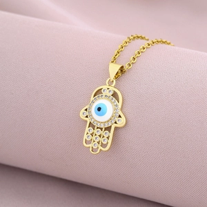 Detailed macro view of 18K gold-plated Hamsa Hand pendant with blue evil eye and zircons
