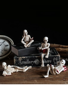 Macro shot of creative skeleton figurines reading books on vintage wooden desk decor