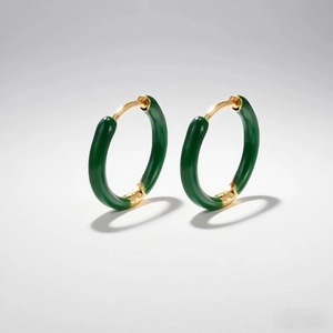 Macro detail of dark green enamel earrings with gold-plated metal hinge closure